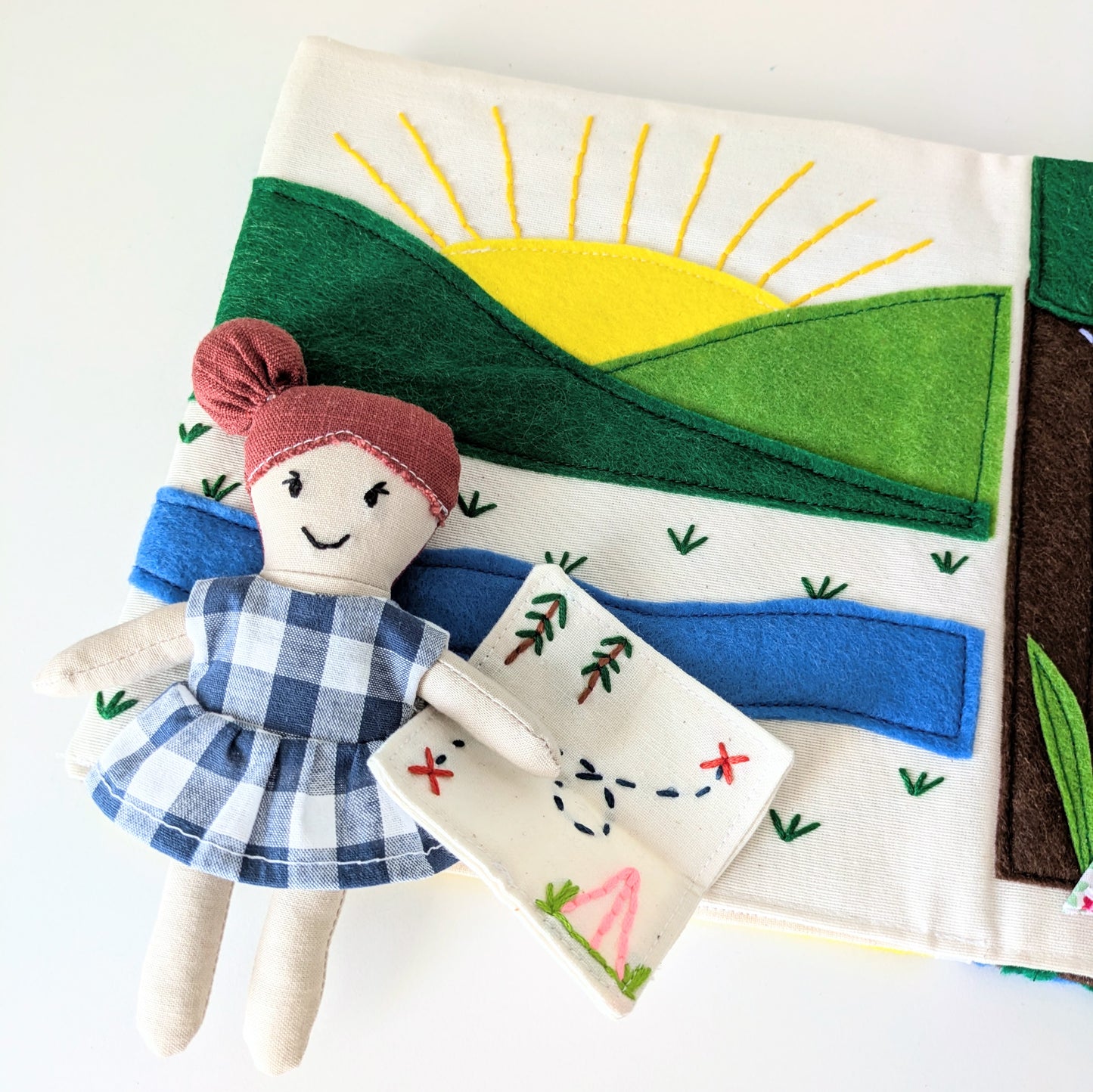 Close-up of the Adventure Book interior pages featuring felt motifs and creative stitching.