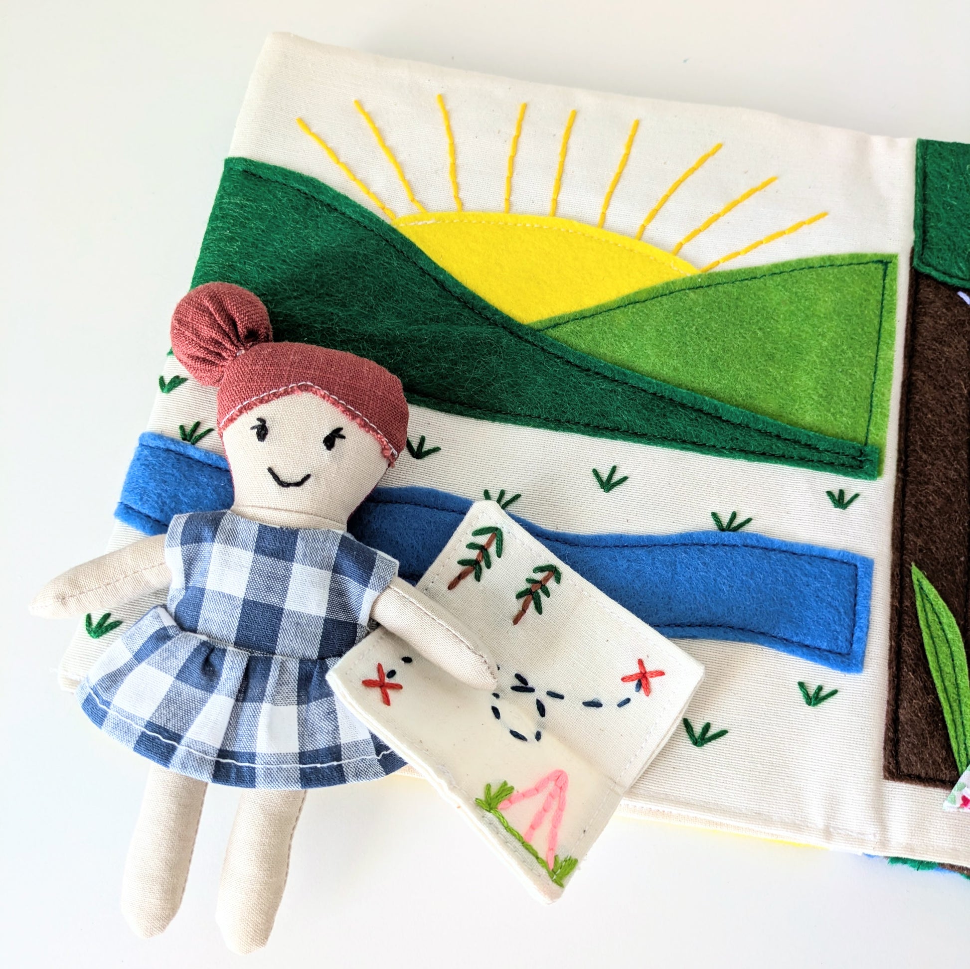 Close-up of the Adventure Book interior pages featuring felt motifs and creative stitching.