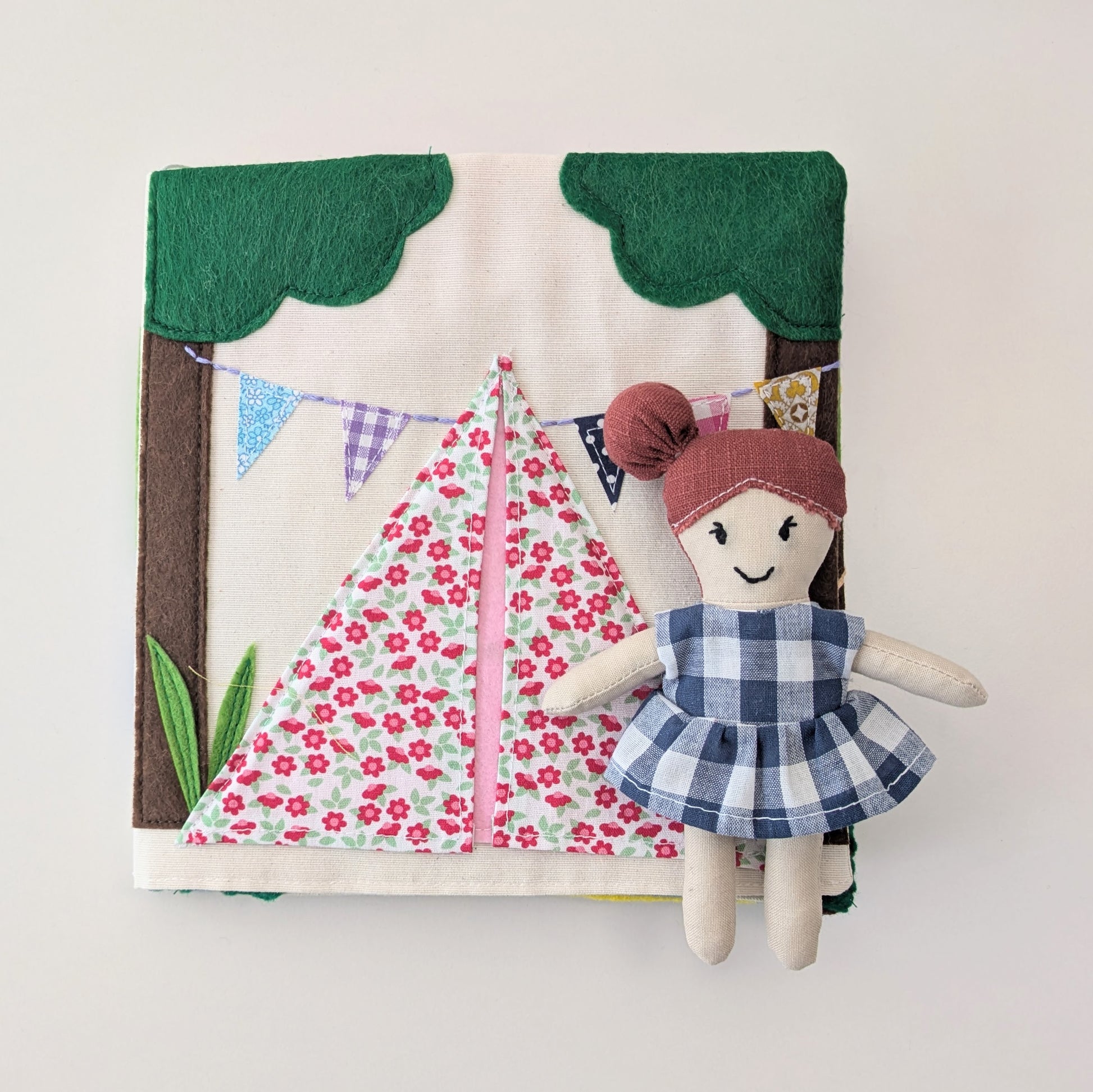 Fabric doll with a dress and a treehouse background on a white background