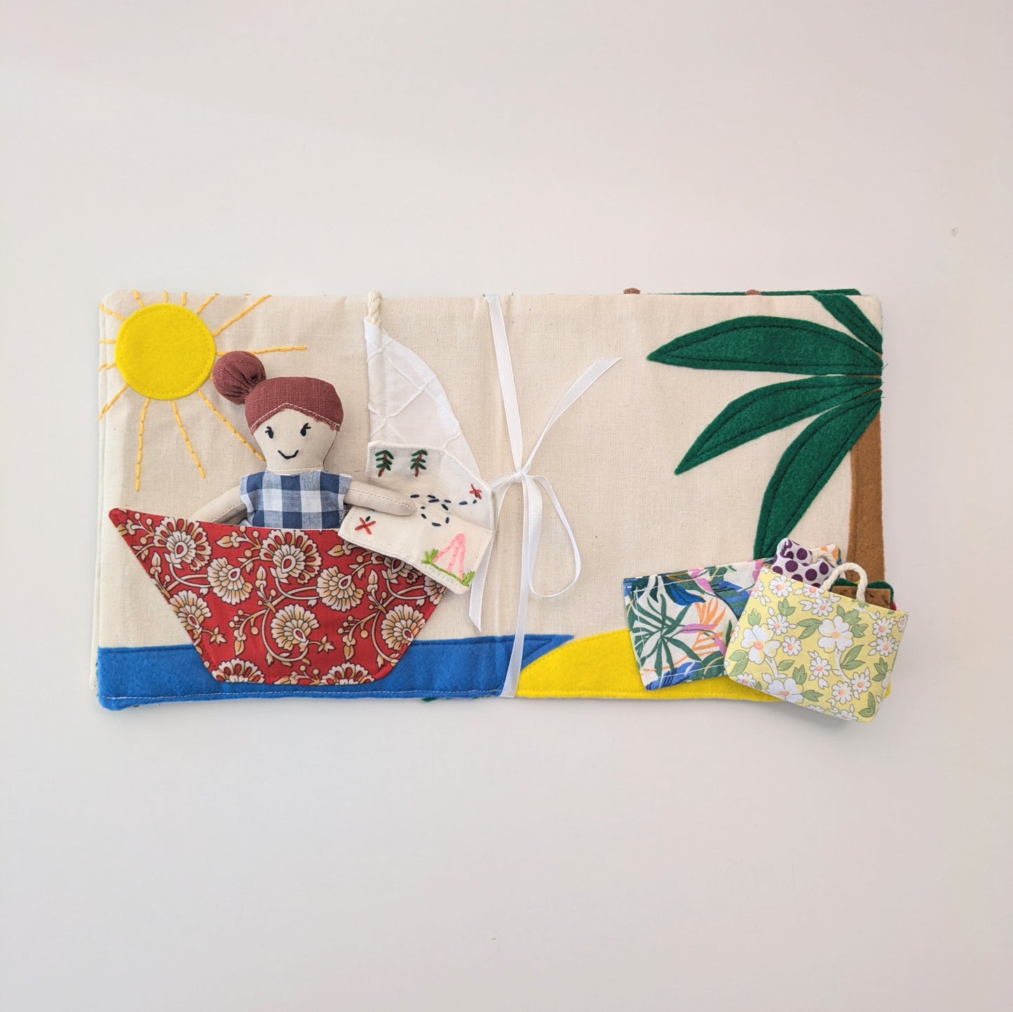Fabric package with a doll and small bags on a white background