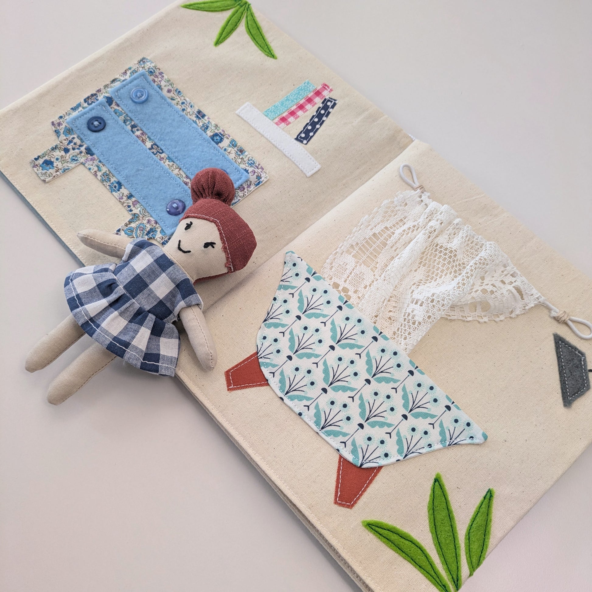 Close-up of dollhouse room layout showing fabric textures and decorative stitching.