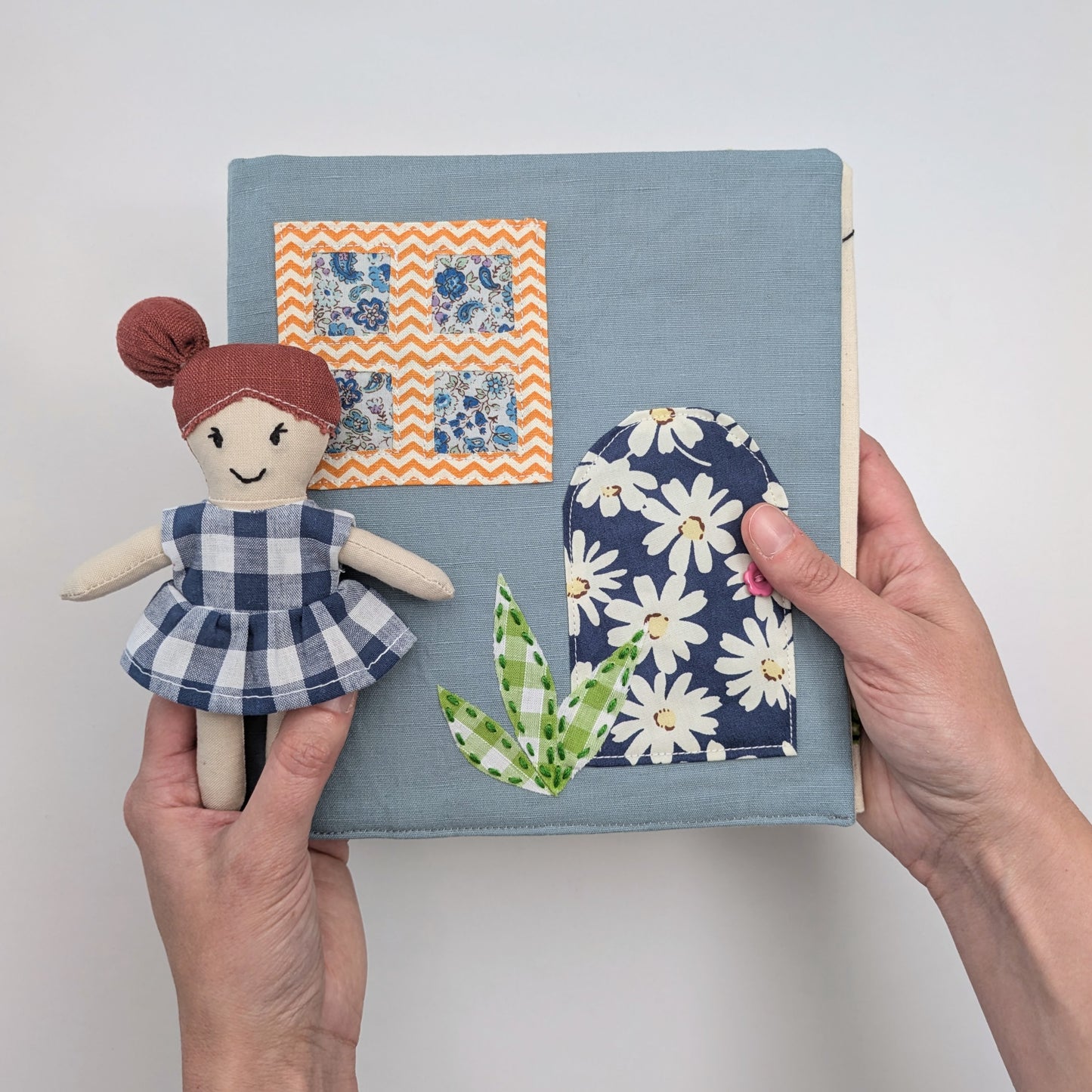 Fold-up dollhouse shown in hand for size reference.